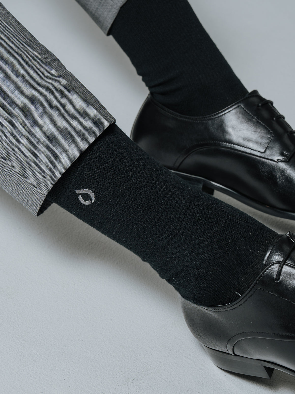 Black DryStep Crew socks with black leather Oxford shoes and grey suit trousers
