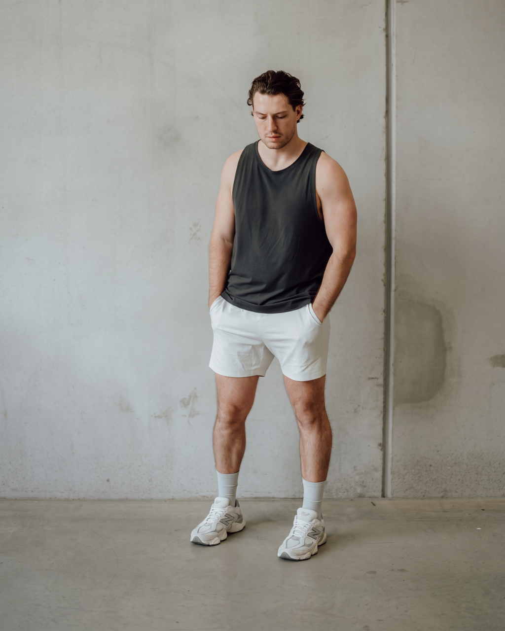 Man in DryStep stone grey crew socks, tank top, shorts and white sneakers