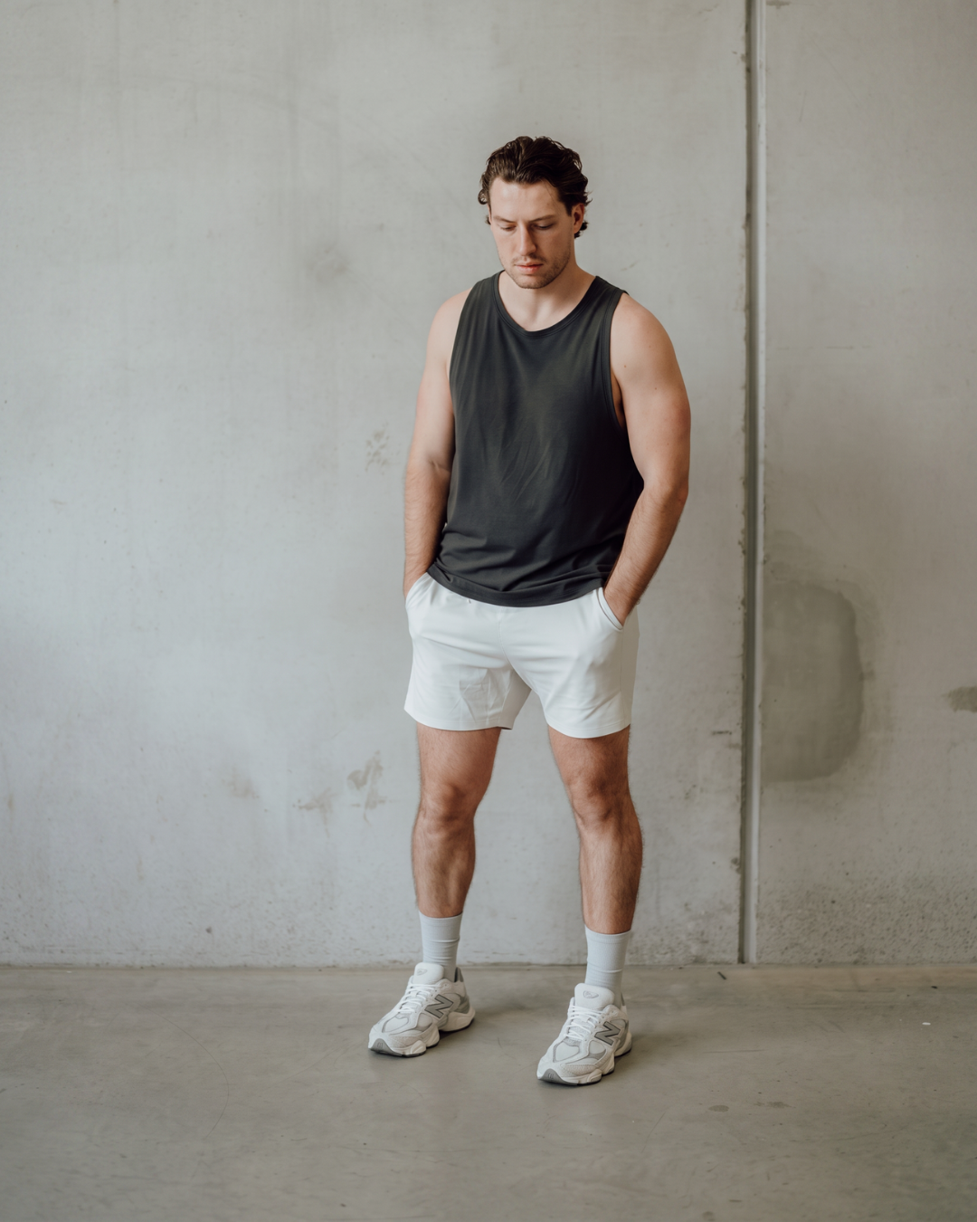 Man in DryStep stone grey crew socks, tank top, shorts and white sneakers