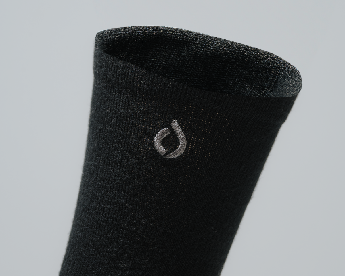 Close-up of the fine knit on a black DryStep sock cuff with the grey embroidered drop logo
