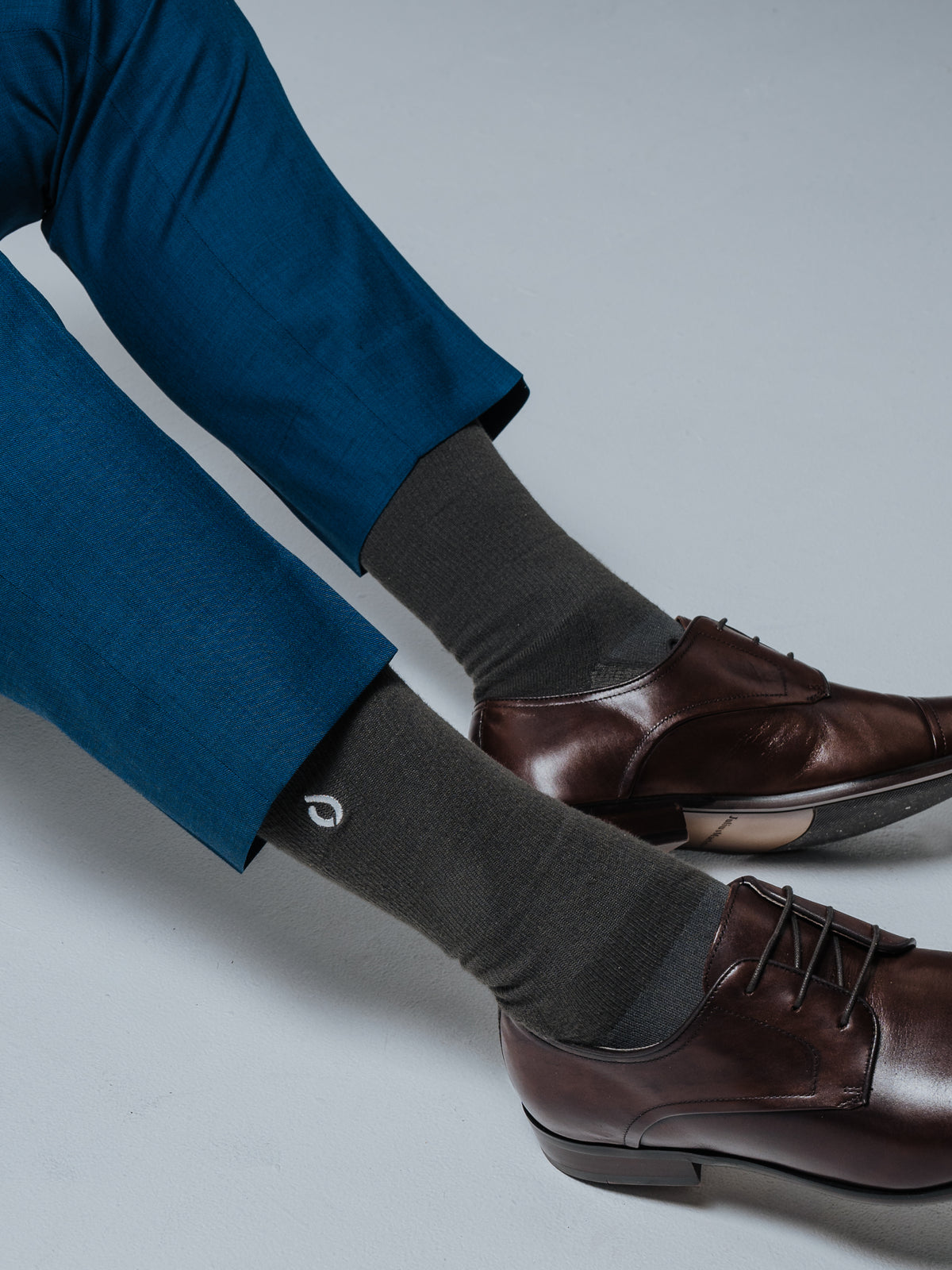 Dark grey DryStep Crew socks with brown leather Derby shoes and blue suit trousers