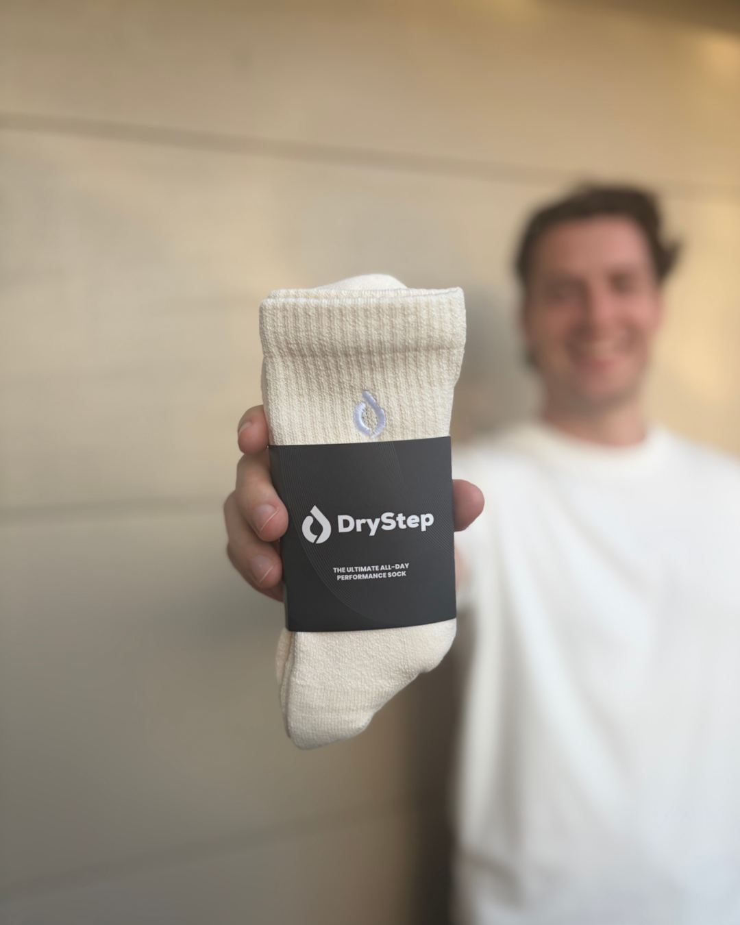 Man holding DryStep Vanilla performance socks in packaging