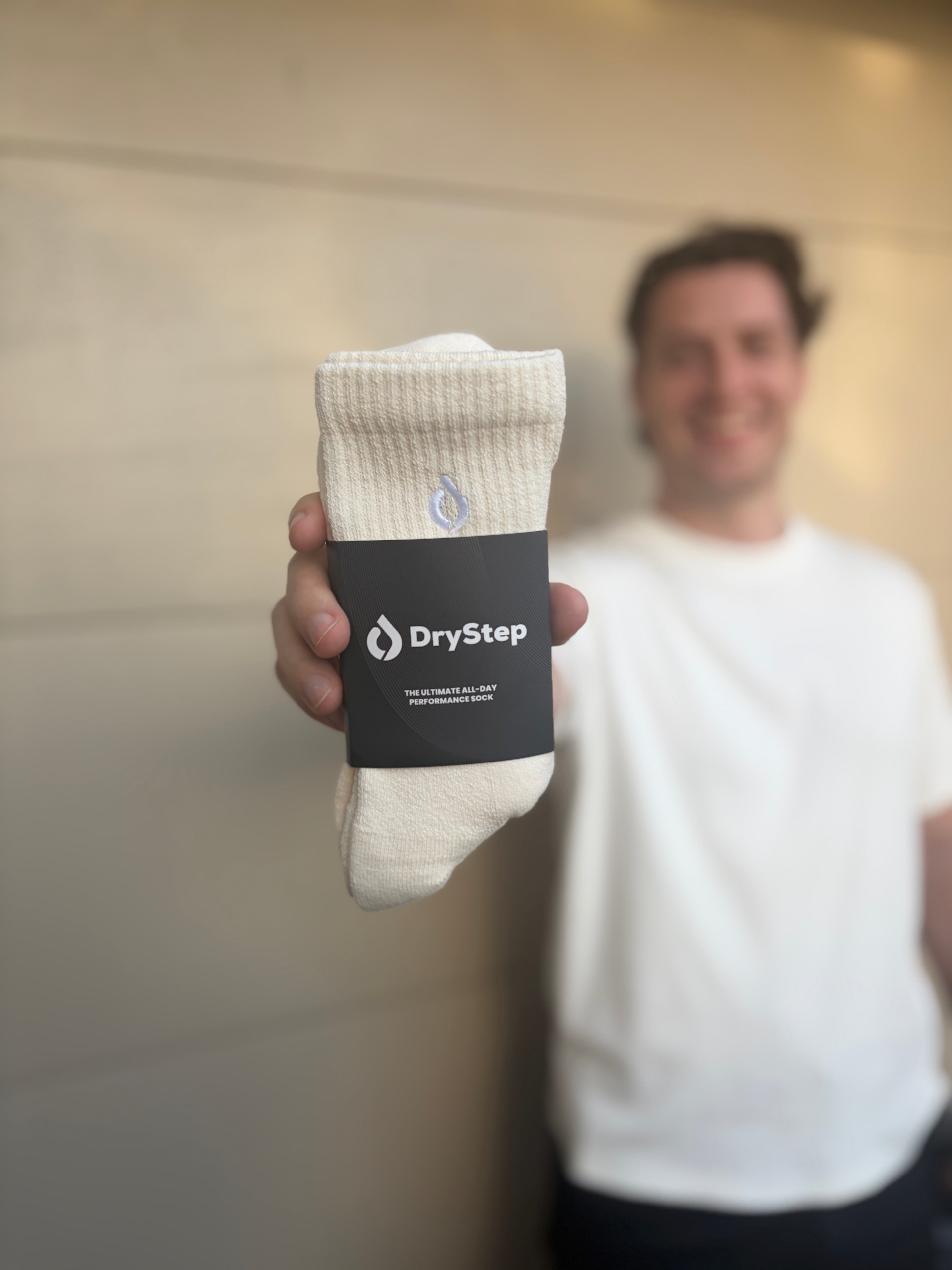Man holding DryStep Vanilla performance socks in packaging